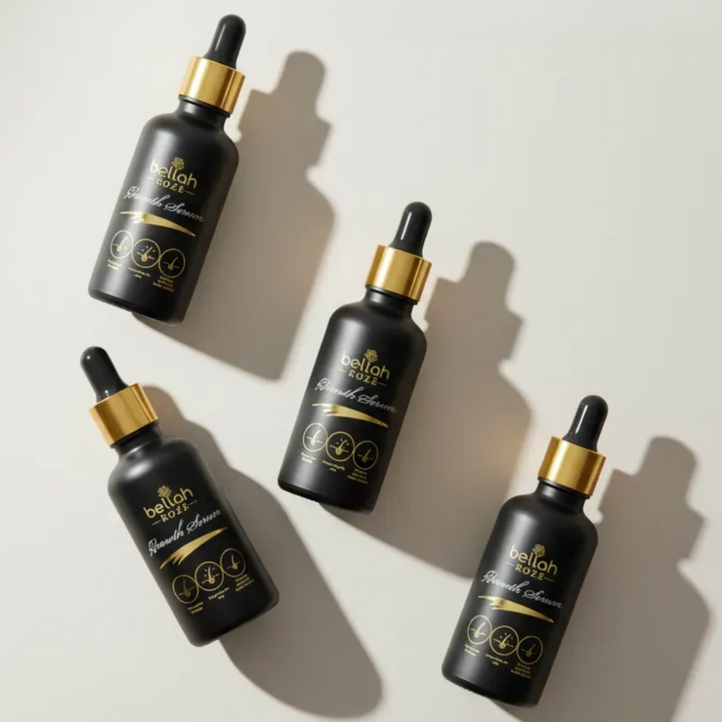 Four black dropper bottles with gold caps on a light background