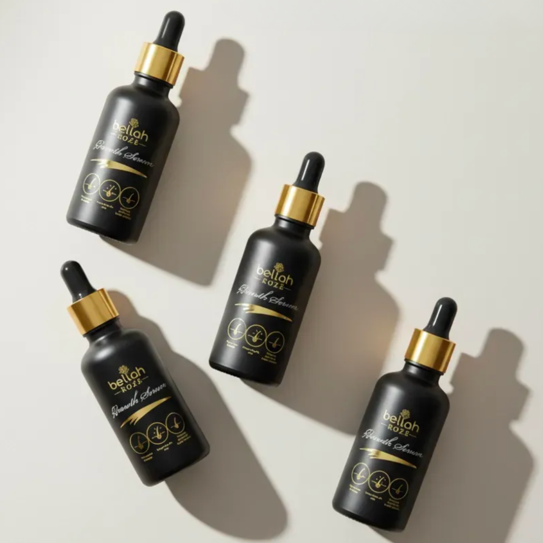 Four black dropper bottles with gold caps on a light background