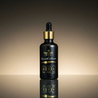 Black dropper bottle with gold cap on a reflective surface and gradient background