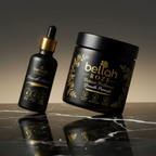 Black bottle with dropper and black container labeled 'bellah ROZE' on a reflective surface.