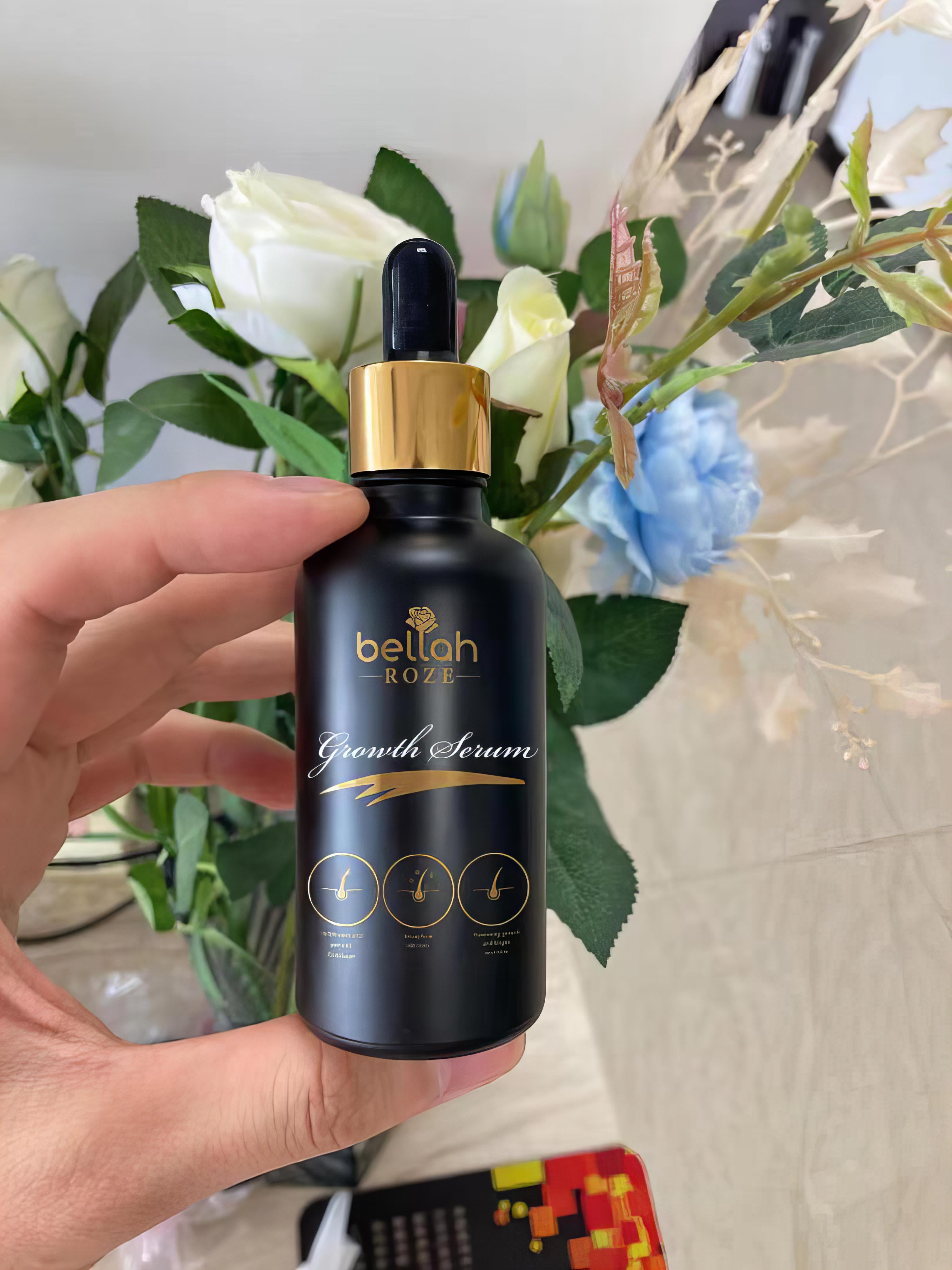 Hand hold hair growth oil in luxury black and gold packaging 
